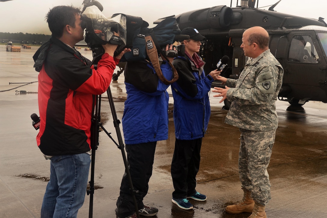 Local and national news media members interview Army Maj. Gen. Robert E. Livingston Jr., right, the adjutant general of the South Carolina National Guard, about the Guard's flood response at McEntire Joint National Guard Base, S.C., Oct. 5, 2015. South Carolina Air National Guard photo by Senior Master Sgt. Edward Snyder