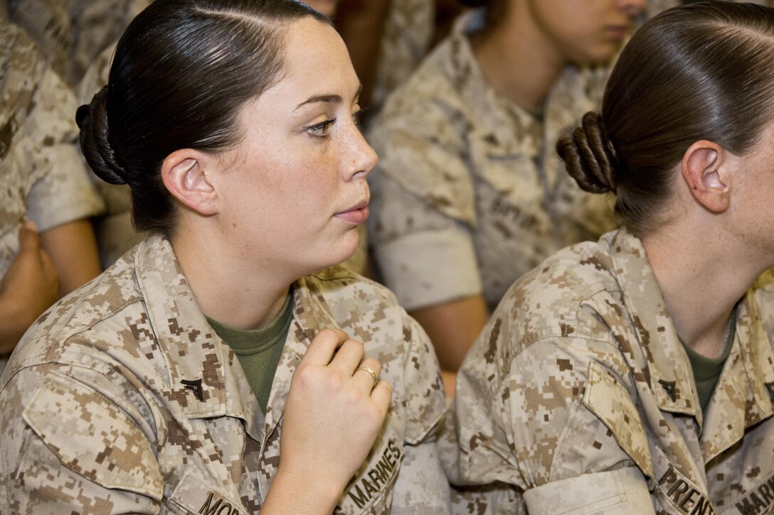 U.S. Marine Corps Lance Cpl. Leila A. Morgan, an avionics Marine with Marine Medium Tiltrotor Squadron 365, touches her rank insignia while Commandant of the Marine Corps, Gen. Robert B. Neller, speaks at Marine Corps Air Station New River, N.C., Oct. 8, 2015. Neller asked Marines to reflect on the work it took to earn it. (U.S. Marine Corps photo by Sgt. Gabriela Garcia/Released)