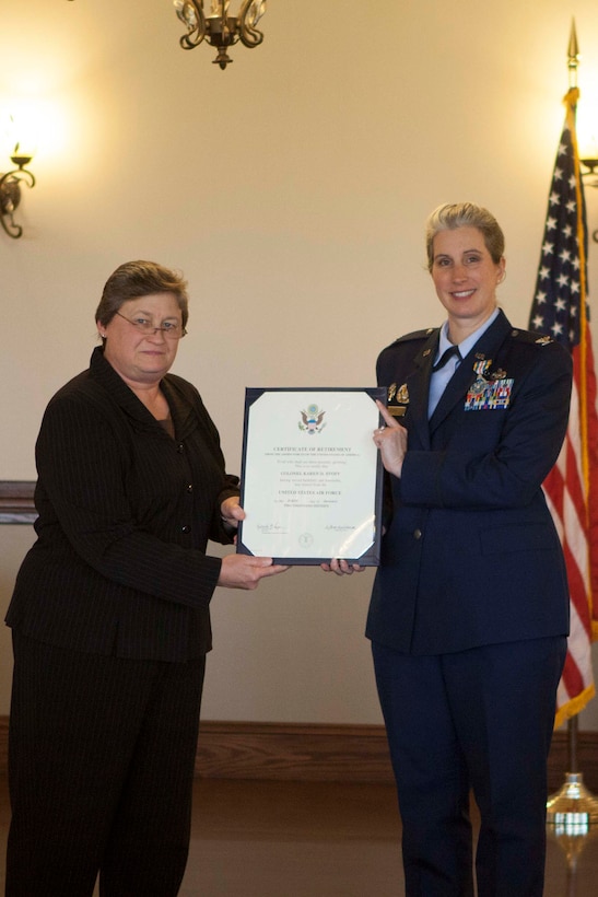 Sonya Gish, director of DLA Distribution process and planning directorate presents Air Force Col. Karen D. Stoff with a certificate of retirement from the United States Air Force.
