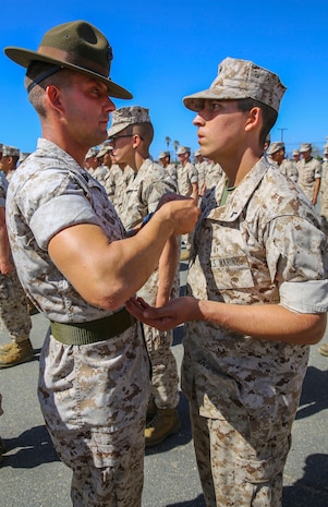 Private First Class Juan Valenzuela, Fox Company, 2nd Recruit Training Battalion, receives his new rank of private first class from Staff Sgt. Michael T. Ambrose, drill instructor, at Edson Range, Marine Corps Base Camp Pendleton, Calif., Oct. 1. Some Marines get promoted meritoriously during recruit training for assisting the recruiting efforts or for accruing college credits. Today, all males recruited from west of the Mississippi are trained at Marine Corps Recruits Depot San Diego. The depot is responsible for training more than 16,000 recruits annually. Fox Company will graduate Oct. 9.