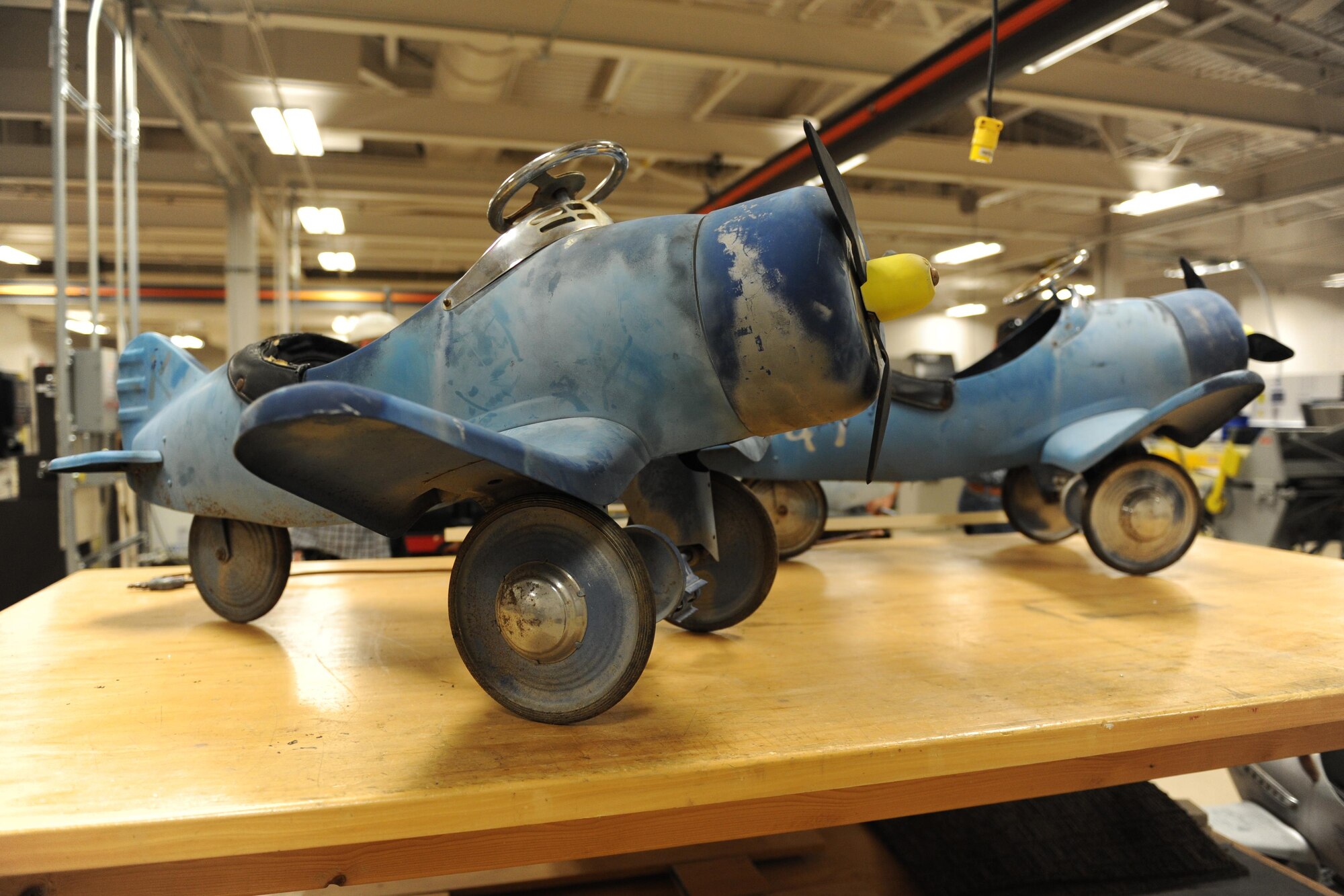 Pedal airplanes sit on a tabletop at the Trainer Development Center during a refurbish project, Oct. 8, 2015, Keesler Air Force Base, Miss. The four pedal airplanes, belonging to the child development center, have been in storage for more than 10 years. (U.S. Air Force photo by Kemberly Groue)