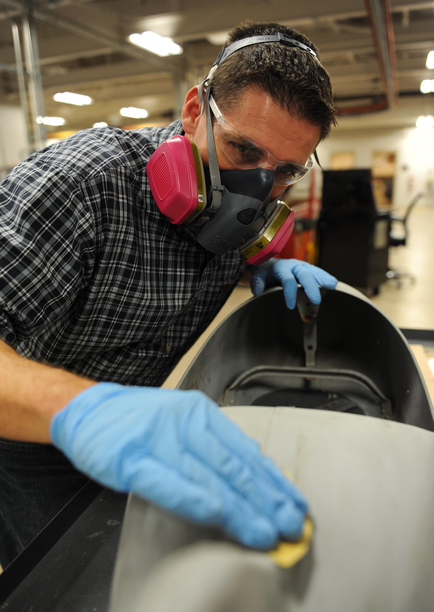 Tomme Lassabe, 81st Training Support Squadron training technology flight chief, sands the paint off a pedal airplane during a refurbish project at the Trainer Development Center, Oct. 8, 2015, Keesler Air Force Base, Miss. The four pedal airplanes, belonging to the child development center, have been in storage for more than 10 years. (U.S. Air Force photo by Kemberly Groue)