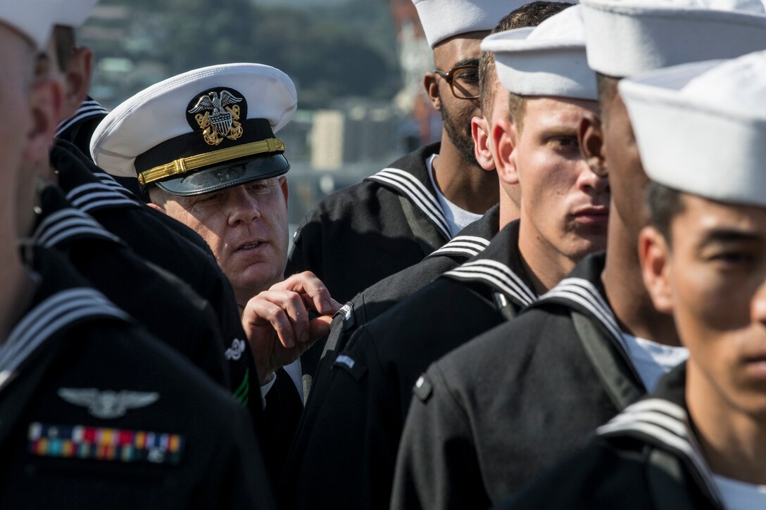 U.S. Navy Lt. Joe Schultz conducts a dress-blue uniform inspection on the flight deck of the aircraft carrier USS Ronald Reagan in Yokosuka, Japan, Oct. 9, 2015. U.S. Navy photo by Petty Officer 3rd Class Ryan McFarlane