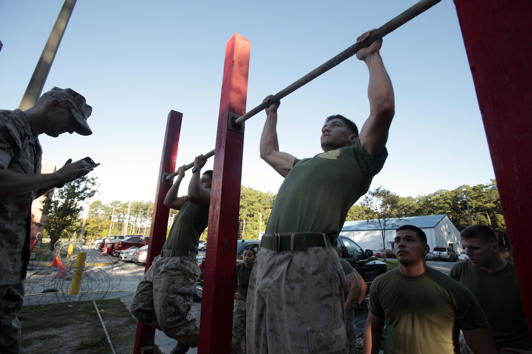 Marines perform pull-ups during a Super Squad Competition hosted by Marine Wing Communications Squadron 28 at Marine Corps Air Station Cherry Point, N.C., Oct. 7, 2015. With a total of seven stations to complete, the Marines powered through physical fatigue, 200 pull-ups divided amongst each individual squad member and memory-challenging exercises. Their ability to work as a team and function under stressful scenarios enables them to provide outstanding support to the Marine Air-Ground Task Force. MWCS-28 provides expeditionary communications for the Aviation Combat Element of the II Marine Expeditionary Force. (U.S. Marine Corps photo by Lance Cpl. Jason Jimenez/Released)