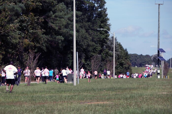 Participants run and walk along a designated course during the 10th Annual Breast Cancer Awareness 5K Paint Run hosted by the Naval Health Clinic at Marine Corps Air Station Cherry Point, N.C., Oct. 9, 2015. The NHC hosted the 5K to promote awareness for breast cancer testing and early detection. According to the American Breast Cancer Society, one in eight women will develop invasive breast cancer over the course of her life time. More than two hundred participants showed up to the 5K to show their support for the cause. (U.S. Marine Corps photo by Lance Cpl. Jason Jimenez/Released)