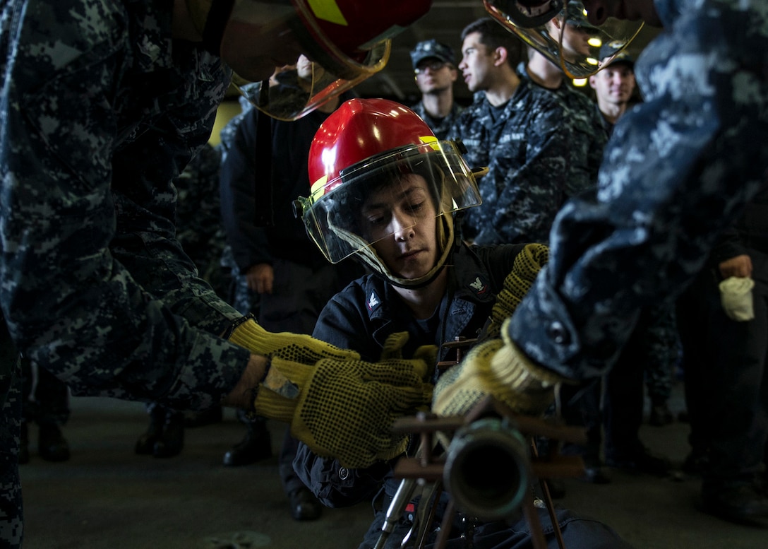 U.S. Navy Petty Officer 3rd Class Berney Jarosz practices pipe-patching during a general quarters drill in the hangar bay of the USS Ronald Reagan in Yokosuka, Japan, Oct. 8, 2015. Jarosz is a machinist's mate. U.S. Navy photo by Petty Officer 3rd Class Nathan Burke