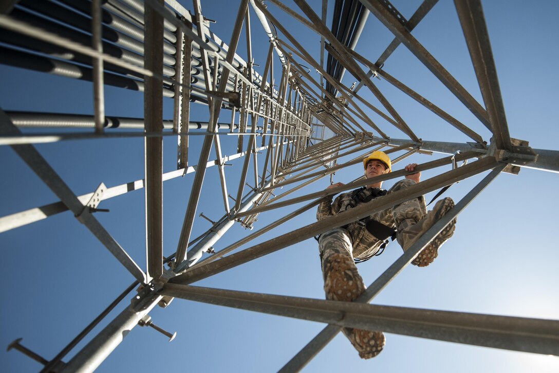 Air Force Senior Airman James Vrtis descends a ground-to-air radio tower at the airfield systems maintenance compound on Nellis Air Force Base, Nev., Oct. 6, 2015. Vrtis is an airfield systems technician with the 57th Operations Support Squadron. U.S. Air Force photo by Staff Sgt. Siuta B. Ika