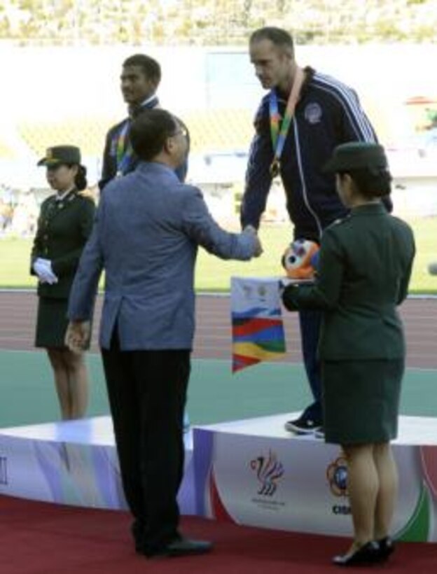U.S. Army Sgt. Robert Browns shakes hands with Korean Track and Field Association Vice President Hwang Gu Hoon after receiving the gold medal for the 100-meter para dash at the CISM World Games in Mungyeong, South Korea, Oct. 5, 2015. Brown finished in 12.5 seconds and to his left is silver medalist Anandan Gunasekaren of India who finished in 12.55.