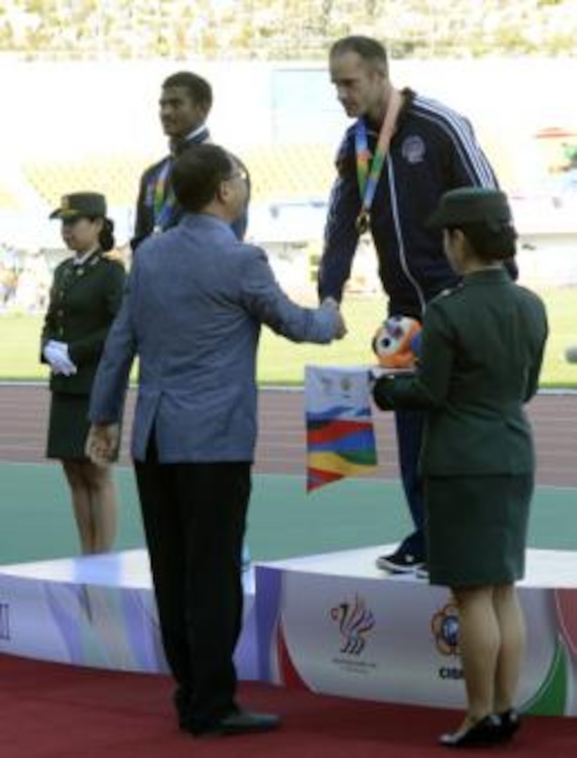 U.S. Army Sgt. Robert Browns shakes hands with Korean Track and Field Association Vice President Hwang Gu Hoon after receiving the gold medal for the 100-meter para dash at the CISM World Games in Mungyeong, South Korea, Oct. 5, 2015. Brown finished in 12.5 seconds and to his left is silver medalist Anandan Gunasekaren of India who finished in 12.55.