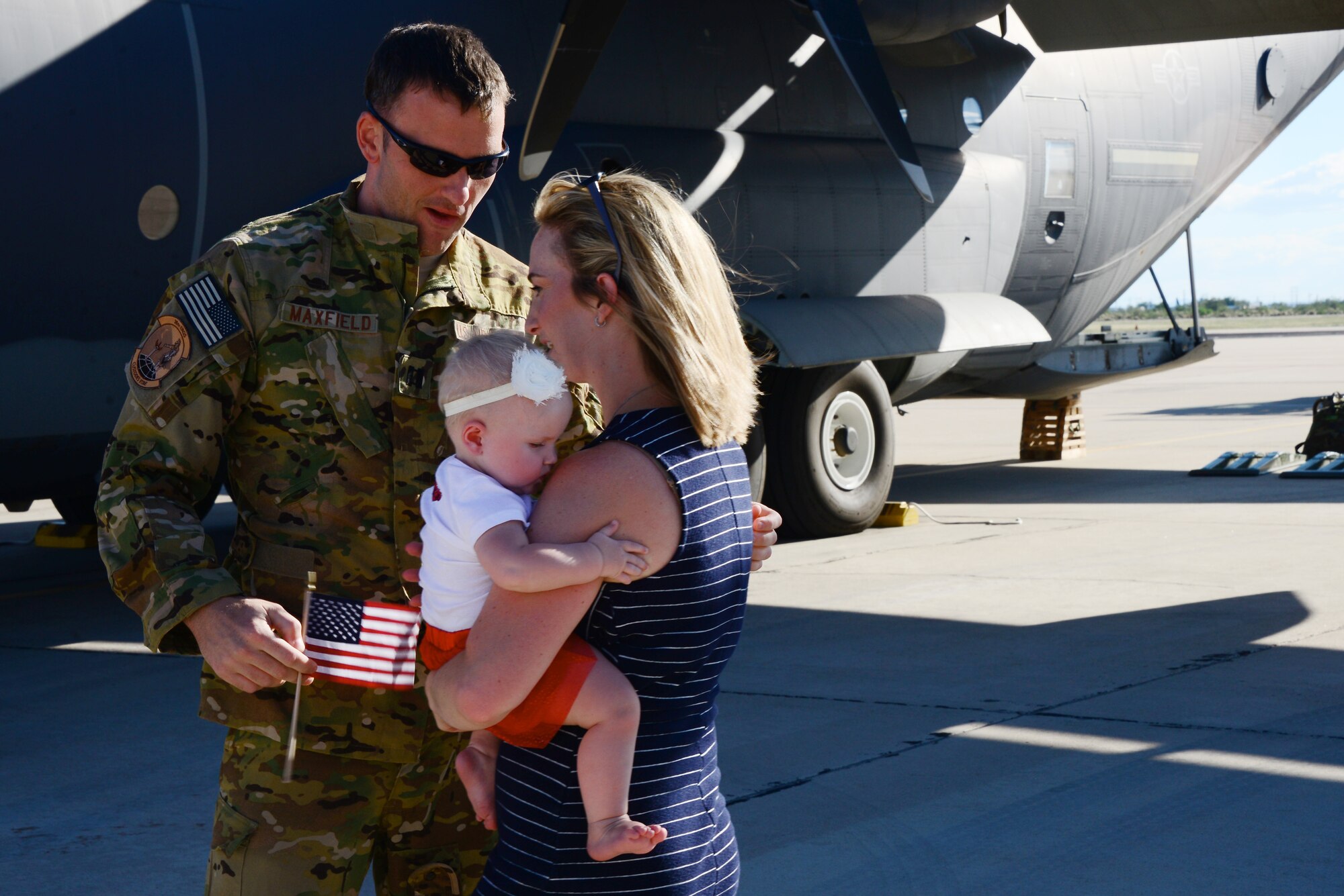 U.S. Air Force Capt. Ronald Maxfield, 79th Rescue Squadron combat systems officer, embraces his family on the flightline at Davis-Monthan Air Force Base, Ariz., Oct. 9, 2015. Two HC-130J Combat King IIs and 25 Airmen returned from a 4-month deployment to Southwest Asia. (U.S. Air Force photo by Airman 1st Class Mya M. Crosby/Released) 