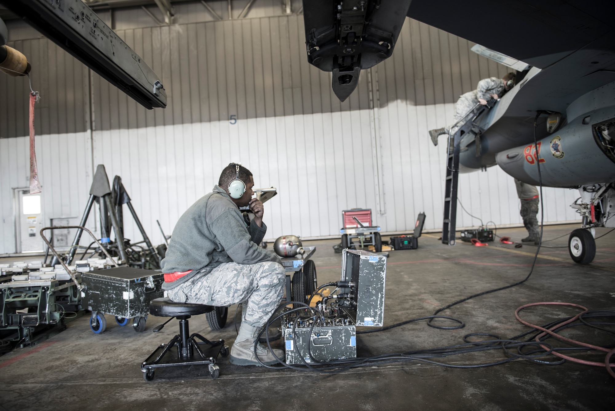 U.S. Air Force Senior Airman Terrence Lawrence, 354th Aircraft Maintenance Squadron aircraft electrical and environmental systems journeyman, troubleshoots an F-16 Fighting Falcon assigned to the 18th Aggressor Squadron at Eieson Air Force Base, Alaska, Oct. 7, 2015. Lawrence was the first Airman to complete a program called “cut training,” which cross utilizes Airmen to fill undermanned crew chief positions. (U.S. Air Force photo by Staff Sgt. Joshua Turner/Released)
