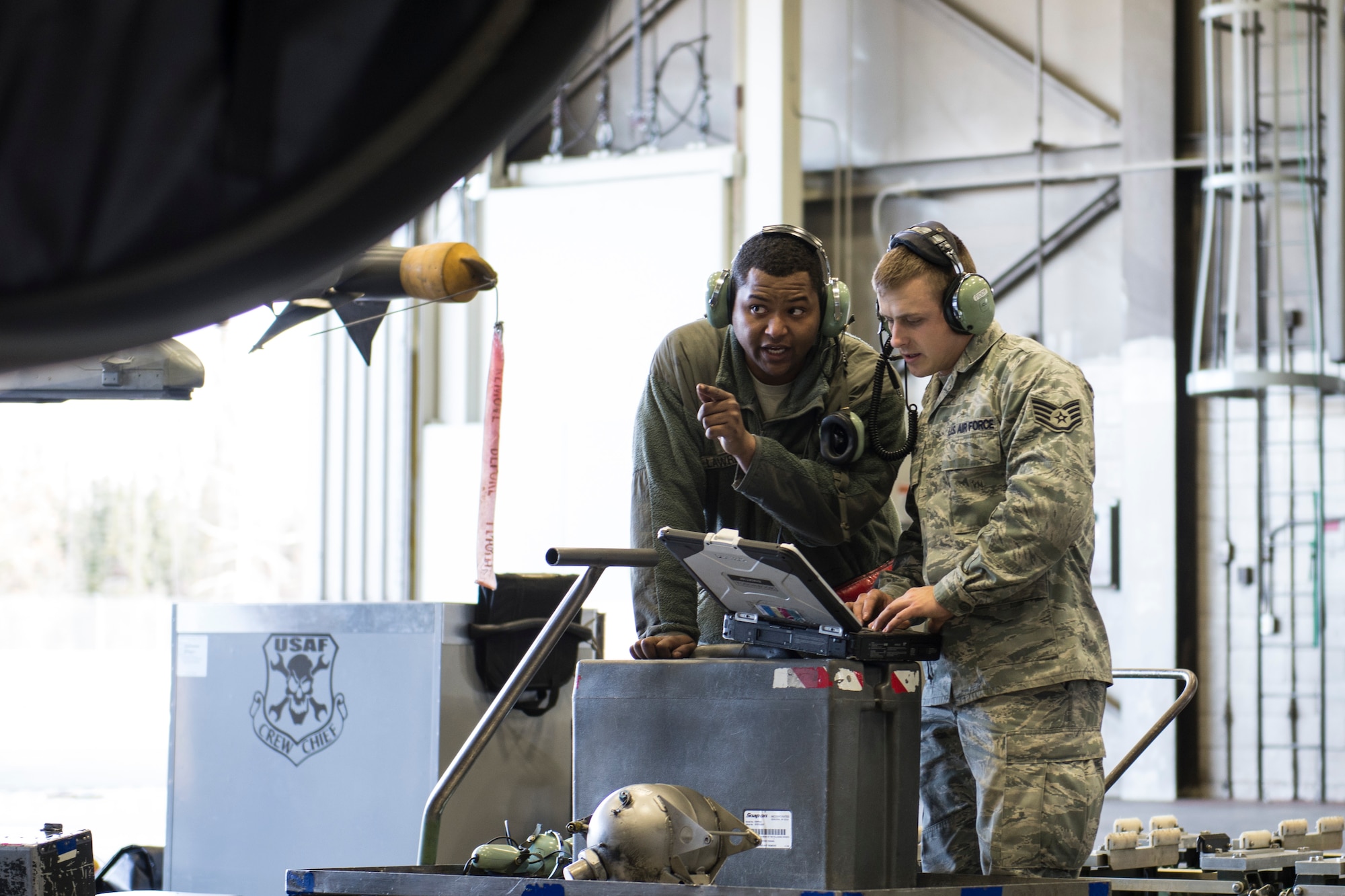 U.S. Air Force Senior Airman Terrence Lawrence and Staff Sgt. Eric Fitch, both 354th Aircraft Maintenance Squadron maintenance specialists, troubleshoot an F-16 Fighting Falcon aircraft assigned to the 18th Aggressor Squadron at Eielson Air Force Base, Alaska, Oct. 7, 2015. Lawrence was the first Airman to complete a program called “cut training,” which cross utilizes Airmen to fill undermanned crew chief positions. (U.S. Air Force photo by Staff Sgt. Joshua Turner/Released)