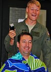 1st Lt. Matthew Anderson, 6th Special Operations Squadron pilot, prepares to shave the head of his boss, Lt. Col. Casey Ward, 6th SOS commander, at Duke Field, Fla., Oct. 8, 2015. Ward and two others with ties to the squadron put their hair on the line as part of a teambuilding event for the special operations unit. (U.S. Air Force photo/Lt. Col. James R. Wilson)
