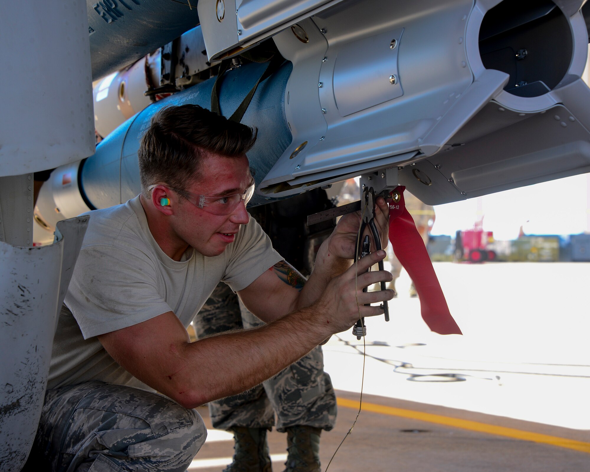 U.S. Air Force Airman 1st Class Christopher Sisk, 354th Aircraft Maintenance Unit load crew team member, wires a control computer group of a Guided Bomb Unit-12 Paveway II during a load crew of the quarter contest at Davis-Monthan Air Force Base, Ariz., Oct. 2, 2015. The selected Airmen for the contest were hand-picked from their unit leadership to compete. (U.S. Air Force photo by Airman 1st Class Mya M. Crosby/Released)