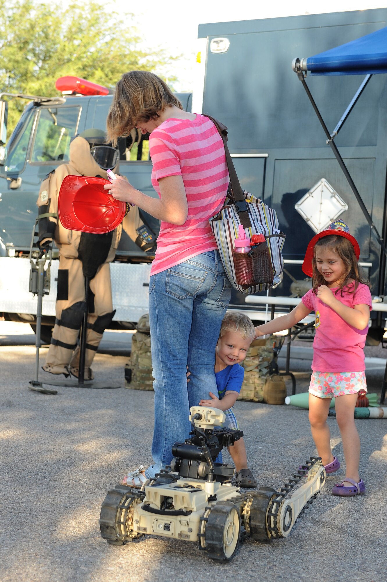 The family of U.S. Air Force Staff Sgt. Jamie Matekaitis, 355th Maintenance Group quality assurance inspector, family interacts with the 355th Civil Engineer Squadron Explosive Ordnance Disposals’ micro tactical ground robot during a National Night Out event at Davis-Monthan Air Force Base, Ariz., Oct. 7, 2015. The robot was part of the display EOD had for the event hosted by Soaring Heights Communities. The event was held to educate the public about all the emergency services, and featured displays by the 355th Security Forces Squadron, 355th Civil Engineer Squadron, 355th Aerospace Medical Squadron Bioenvironmental Engineering Flight and the U.S. Border Patrol. (U.S. Air Force photo by Senior Airman Cheyenne A. Powers/Released)