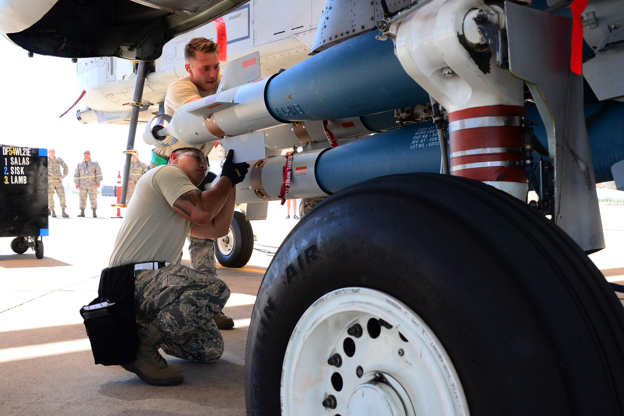 Airmen assigned to the 354th Aircraft Maintenance Unit, work together to load a Guided Bomb Unit-12 Pavement II onto an A-10 Thunderbolt II during a load crew of the quarter contest at Davis-Monthan Air Force Base, Ariz., Oct. 2, 2015. Load crew from the 354th AMU and the 924th Aircraft Maintenance Squadron competed against each other for the contest. (U.S. Air Force photo by Airman 1st Class Mya M. Crosby/Released)