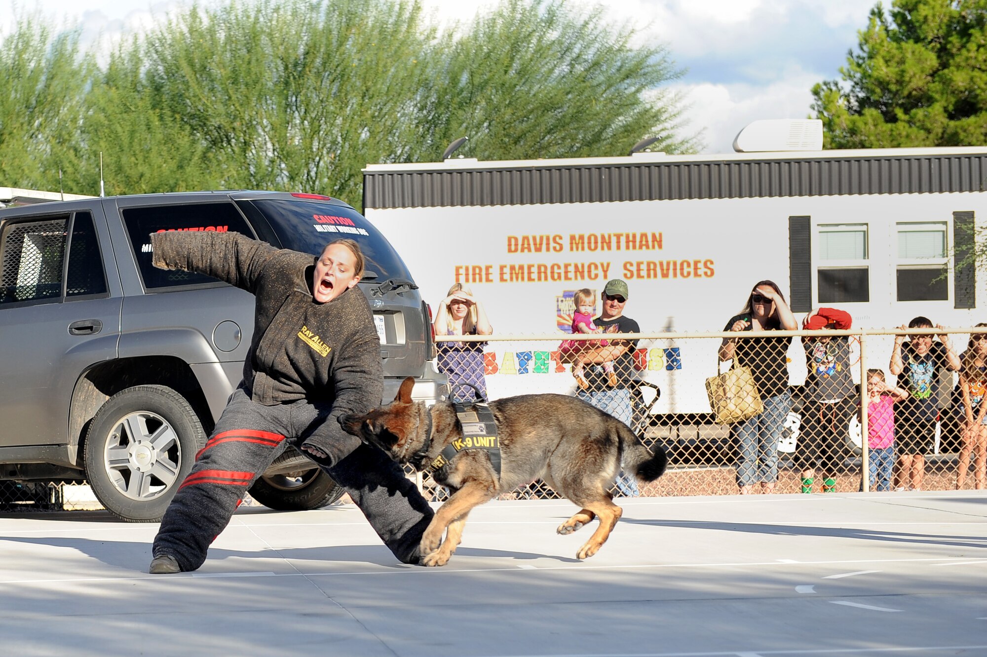 U.S. Air Force Staff Sgt. Lori Lemay, 355th Security Forces Squadron military working dog handler, and Emor, 355th SFS MWD demonstrate how a MWD can attack an aggressor, during a National Night Out event at Davis-Monthan Air Force Base, Ariz., Oct. 7, 2015. The National Night Out event was held by the National Association of Town Watch and co- sponsored locally by Soaring Heights Communities. The night out is designed to heighten crime and drug prevention awareness, generate support for, and participation in, local anticrime efforts, and strengthen neighborhood spirit and security organization. (U.S. Air Force photo by Senior Airman Cheyenne A. Powers/Released)