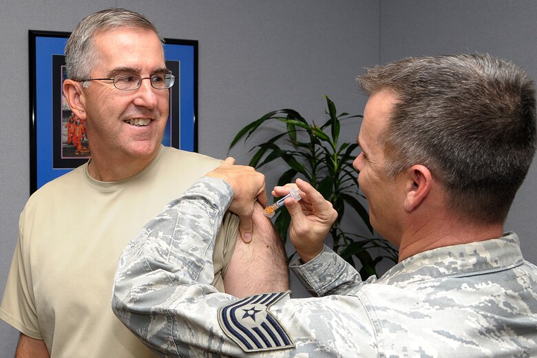 PETERSON AIR FORCE BASE, Colo. – Gen. John Hyten, Air Force Space Command commander, receives his flu shot from Tech. Sgt. Christopher Corley, 21st Medical Operations Squadron. Active Duty and other beneficiaries (including retirees) age 3 years and older can attend the mass flu line at the Peterson Youth Center gym from 6 a.m. to 6 p.m. Oct. 15 for their flu vaccine. The Immunization clinic will have flu vaccine for all beneficiaries beginning 16 Oct.  (courtesy photo) 