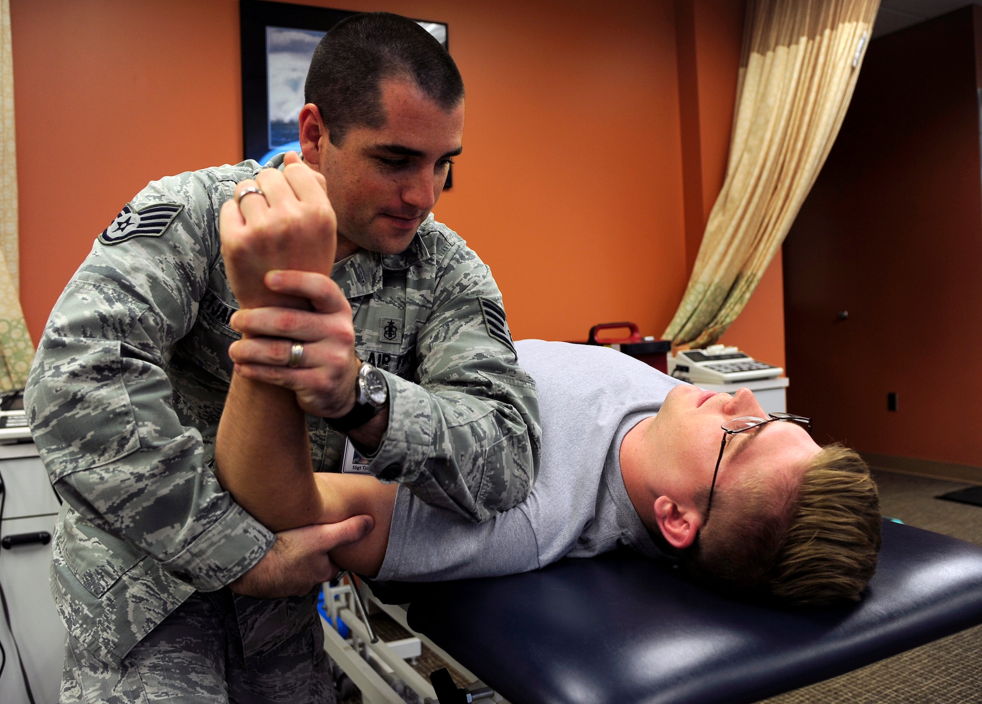 Staff Sgt. Justen Tjarks, 30th Medical Operations Squadron flight chief of health promotions, assists Senior Airman Daniel Dykema, 30th Civil Engineer Squadron engineering journeyman, with different forms of stretching, Oct. 6, 2015, Vandenberg Air Force Base, Calif. Tjarks works hands-on with each patient to ensure a safe and effective recovery. (U.S. Air Force photo by Senior Airman Kyla Gifford/Released)