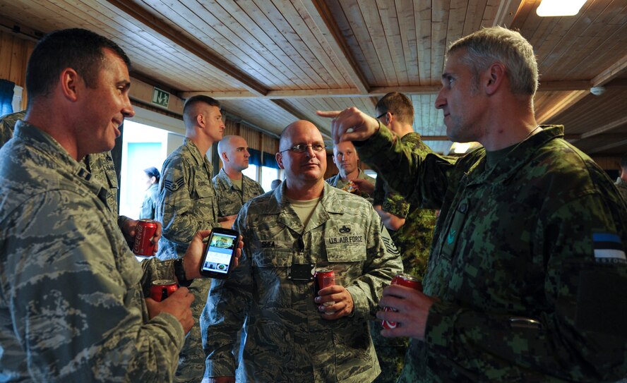 Chief master sergeant of the Estonian air force, Janis Jallai, explains the translation of a local restaurants name to 74th Expeditionary Fighter Squadron Airmen during an icebreaker event at Amari Air Base, Estonia, Oct. 1, 2015. The event was designed to bring the 74th EFS Airmen together with the NATO allies they will spend the next several months working alongside to build relationships and further develop interoperability. (U.S. Air Force photo by Andrea Jenkins/Released)