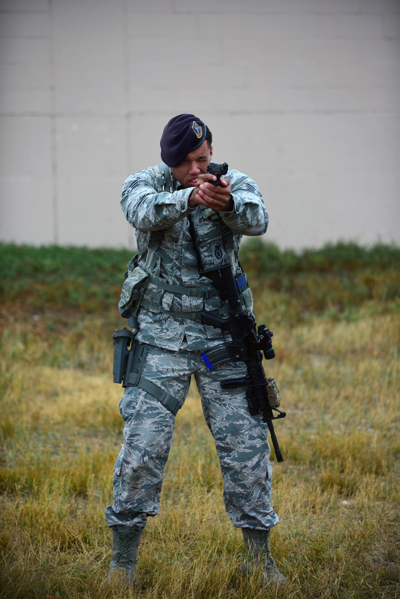 Senior Airman Albert Woods, 28th Security Forces Squadron response force member, aims his M-9 pistol downrange during a Shoot, Move, Communicate training event at Ellsworth Air Force Base, S.D., Sept. 29, 2015. Airmen practiced transitioning from rifle to sidearm while keeping their eyes on the target during a firefight. (U.S. Air Force photo by Airman 1st Class James L. Miller/Released)