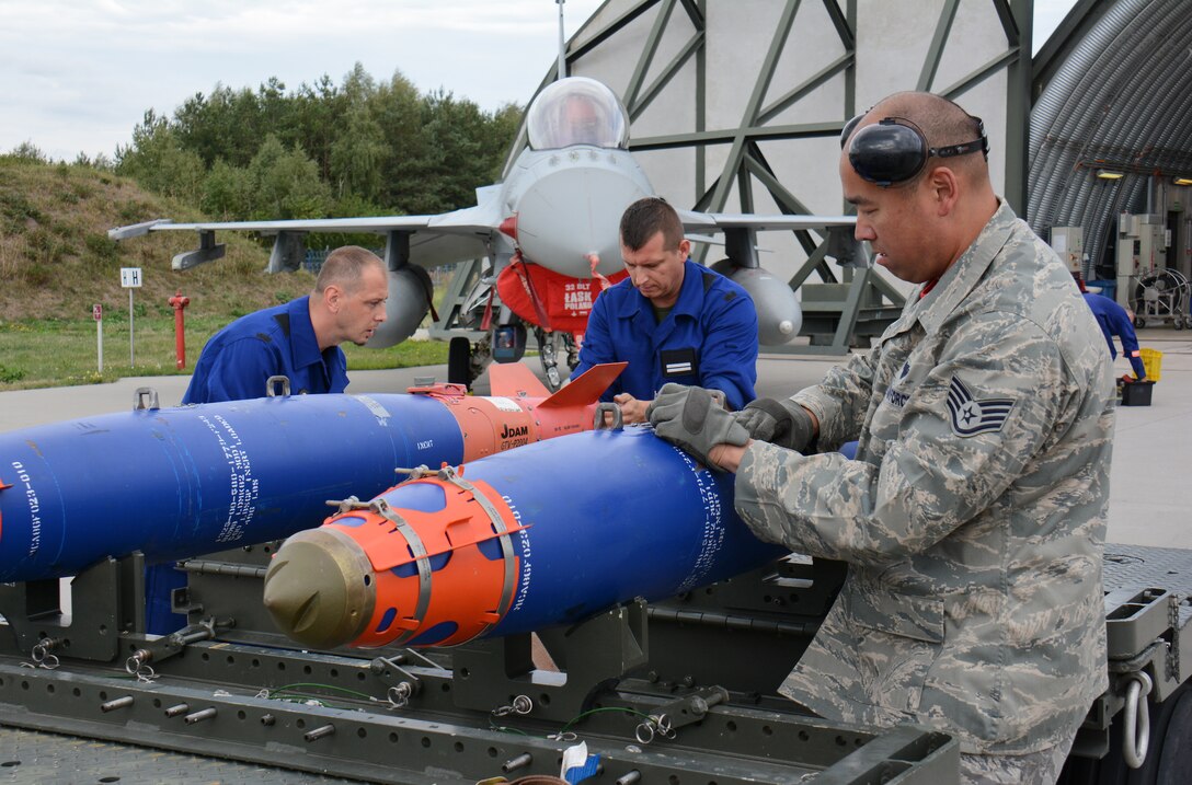 U.S. Air Force Staff Sgt. Victor Jeng, right, aircraft armament specialist with the Wisconsin Air National Guard's 115th Fighter Wing faces off against his counterparts from Poland's 10th Fighter Squadron during a friendly weapons load competition at Łask Air Base, Poland Sept. 18, 2015. The Wisconsin Airmen are joining the 52nd Fighter Wing at Spangdahlem Air Base, Germany to train with the Polish air force during U.S. Aviation Detachment rotation 15-4. The annual training exercise hosted by the Av-Det is designed to enhance bilateral defense ties between Poland and the United States, while strengthening the interoperability of NATO Allies. (U.S. Air National Guard Photo by Master Sgt. Paul Gorman/Released)