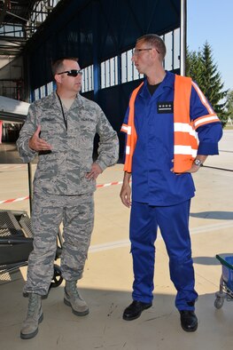 U.S. Air Force Master Sgt. John Schomburg, left, aircraft armament specialist for the Wisconsin Air National Guard's 115th Fighter Wing compares aircraft maintenance procedures with a Polish maintenance officer from the 10th Fighter Squadron at Łask Air Base Sept. 1, 2015, while deployed in support of U.S. Aviation Detachment Rotation 15-4. The annual training exercise hosted by the Av-Det is designed to enhance bilateral defense ties between Poland and the United States, while strengthening the interoperability of NATO Allies. (U.S. Air National Guard Photo by Master Sgt. Paul Gorman/Released)