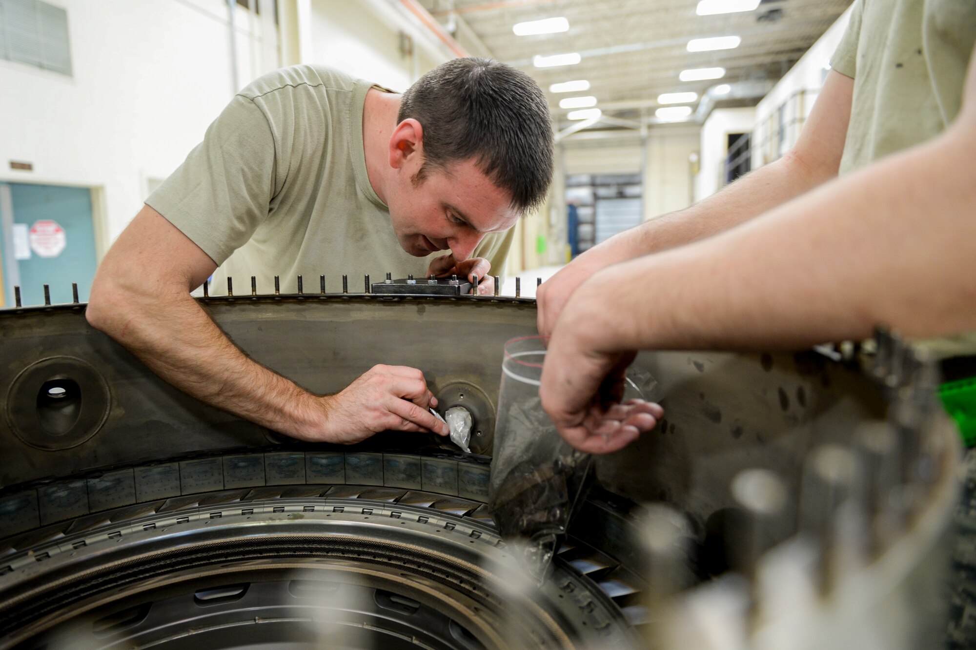 U.S. Air Force Staff Sgt. Jonathan Royder, a 354th Maintenance Squadron aerospace propulsion craftsman, extracts bolts from a combustion diffuser nozzle assembly Oct. 8, 2015, in the engine shop at Eielson Air Force Base, Alaska. Royder serviced the jet engine as part of an engine rebuild involving a complete tear down and inspection of all parts. (U.S. Air Force photo by Senior Airman Peter Reft/Released)