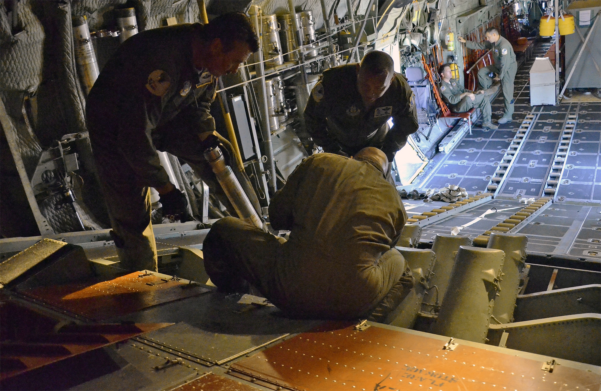 Air Force Reserve aircrew members load cannisters of sea dye into the flare launcher system of an HC-130P/N King aircraft prior to launching a search-and-rescue mission. The dye, which spreads into a large, bright flourescent green patch in seawater, is used to mark the location of a survivor during a search operation. The reservists are members of the 920th Rescue Wing, the Air Force Reserve’s only rescue unit. (U.S. Air Force photo/Master Sgt. Paul Flipse)