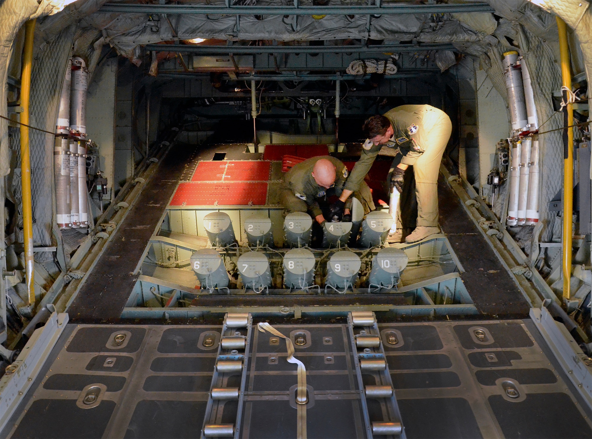 Air Force Reserve aircrew members load cannisters of sea dye into the flare launcher system of an HC-130P/N King aircraft prior to launching a search-and-rescue mission. The dye, which spreads into a large, bright flourescent green patch in seawater, is used to mark the location of a survivor during a search operation. The reservists are members of the 920th Rescue Wing, the Air Force Reserve’s only rescue unit. (U.S. Air Force photo/Master Sgt. Paul Flipse)