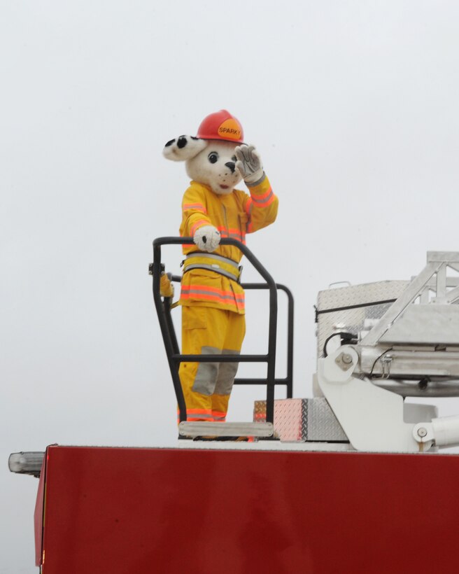 Sparky the Fire Dog waves as the Ellsworth fire department makes their way through base neighborhoods during the Fire Prevention Week parade and open house at Ellsworth Air Force Base, S.D., Oct. 3, 2015. Sparky has been the official mascot for the National Fire Protection Association since 1951. (U.S. Air Force photo by Airman 1st Class Denise M. Nevins/Released)