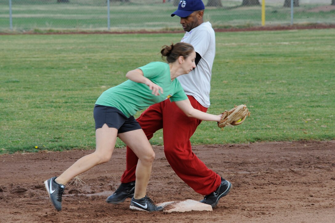 Capt Betsy Reese, 75 MDOS, tries to tag out CMSgt Rodney Gaither, 75 ABW command chief, at second base during the First Annual Strike-Out Against Domestic Violence Softball Tournament hosted Oct 3, 2015 Hill Air Force Base, Utah. Ten teams particaped in this October Triple Awareness Month event in support of Team Hill’s efforts to better recognize and respond to the signs and symptoms of Drug Abuse, Domestic Violence, and Breast Cancer in their own lives and the lives of friends, family, and coworkers. (U.S. Air Force photo by David Perry)