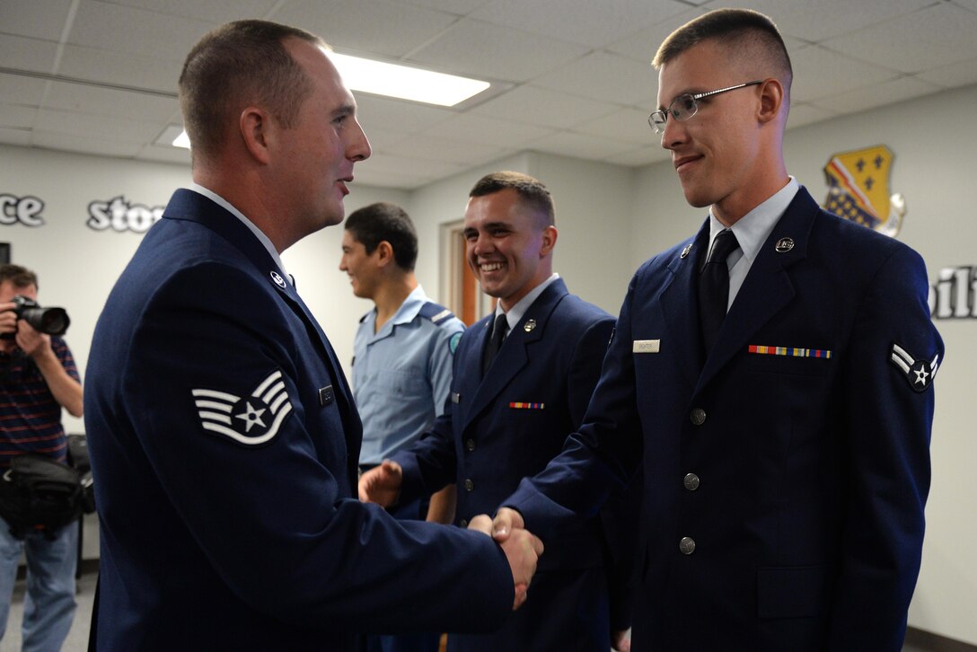 Staff Sgt. Patrick Gordon, 362nd Training Squadron aerospace propulsion instructor, congratulates Airman 1st Class Andrew Richter at the conclusion of his class graduation Oct. 7, 2015, at Sheppard Air Force Base, Texas.  Richter earned the ACE award for maintaining a perfect score through the entire seven blocks of course instruction. He was also the top graduate. Richter will return to his Air National Guard unit in Sioux Falls, S.D. (U.S. Air Force photo/Tech. Sgt. Mike Meares)