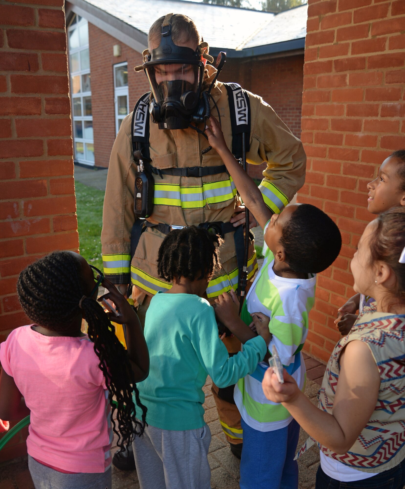 U.S. Air Force Airman 1st Class Coby McCleaf, 100th Civil Engineer Squadron firefighter wears his protective equipment for youth center children Oct. 9, 2015, on RAF Mildenhall, England. The 100th CES Fire Department visited the Child Development Center and youth center to educate children as part of Fire Prevention Week.  (U.S. Air Force photo by Senior Airman Christine Halan/Released)