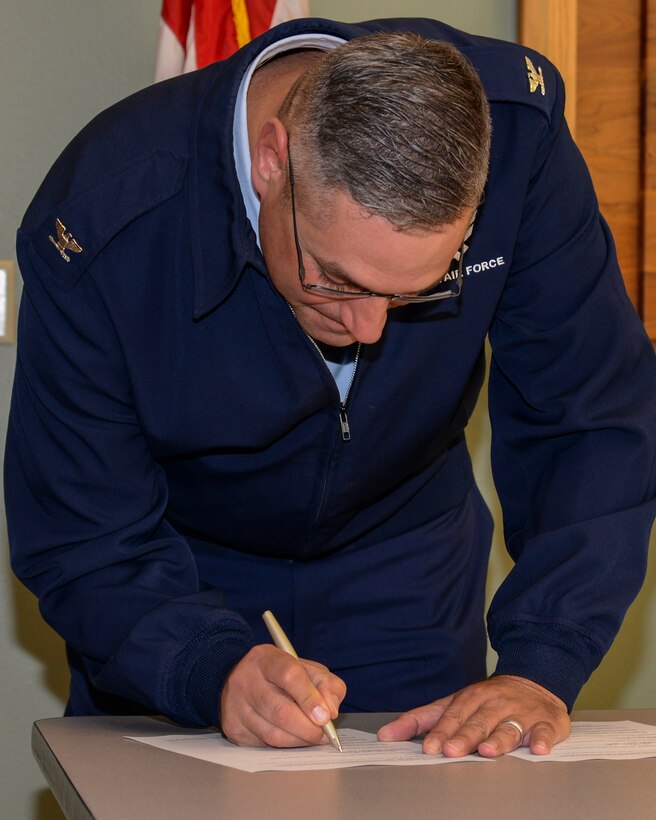 Col. Stephen Kravitsky, 90th Missile Wing commander, F.E. Warren Air Force Base, Wyo., signs an amendment to an agreement between the base and the state Oct. 5, 2015, in the Wyoming State Museum in Cheyenne, Wyo. The amendment allows F.E. Warren to dispose of four of the five deactivated Peacekeeper Missile sites it currently maintains. (U.S. Air Force photo by Senior Airman Jason Wiese)