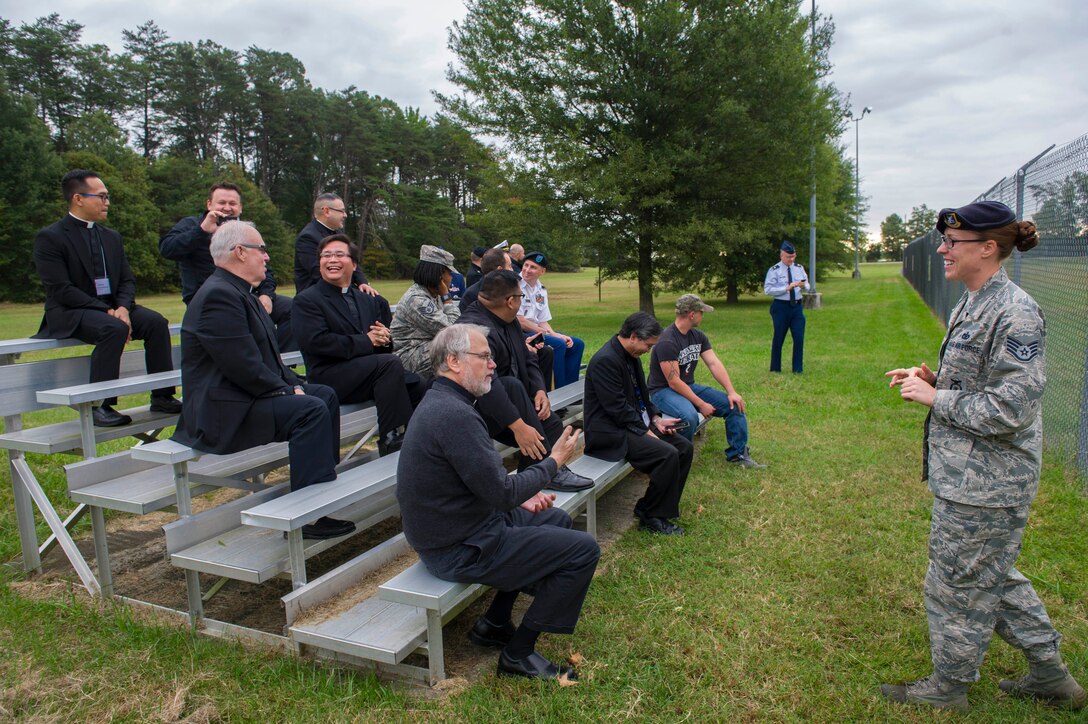 Staff Sgt. Codi Carter, 11th Security Forces Support Squadron military working dog trainer, speaks to priests about what military working dogs do during a base tour Oct. 7, 2015 at Joint Base Andrews, Md. The tour included visiting the 1st Helicopter Squadron, 811th Operation Support Squadron and 11th Security Support Squadron military working dog flight. (Air Force photo by Senior Airman Dylan Nuckolls/Released)