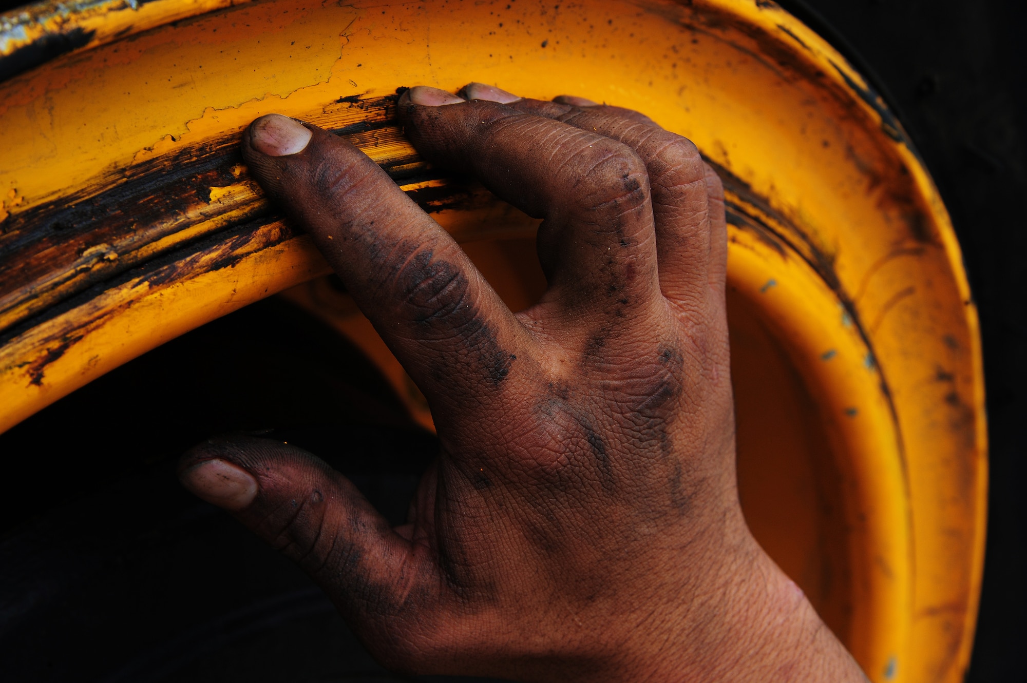 Airman 1st Class Chaiya Thamvongsa, 509th Civil Engineer Squadron pavement and equipment journeyman, inspects a wheel spilt ring at Whiteman Air Force Base, Mo., Oct. 5, 2015. Wheels must be inspected for defects, such as holes or cracks, to prevent damage from occurring to the loader. (U.S. Air Force photo by Senior Airman Keenan Berry/Released)