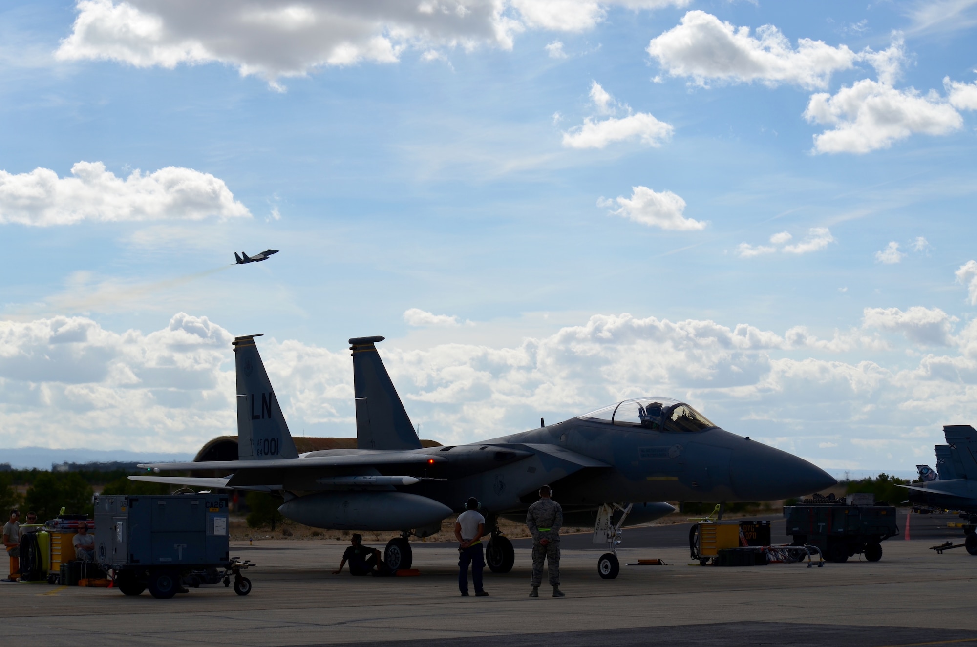 An aircraft takes flight as U.S. Air Force crew members of the 48th Fight Wing prepare an F-15C Eagle for takeoff at the NATO Tactical Leadership Programme in Albacete, Spain, Oct. 8. The TLP is a NATO mission commander’s school designed to provide multi-lateral training and increase interoperability amongst allied partners. (U.S. Air Force Photo by Capt. Sybil Taunton/Released)