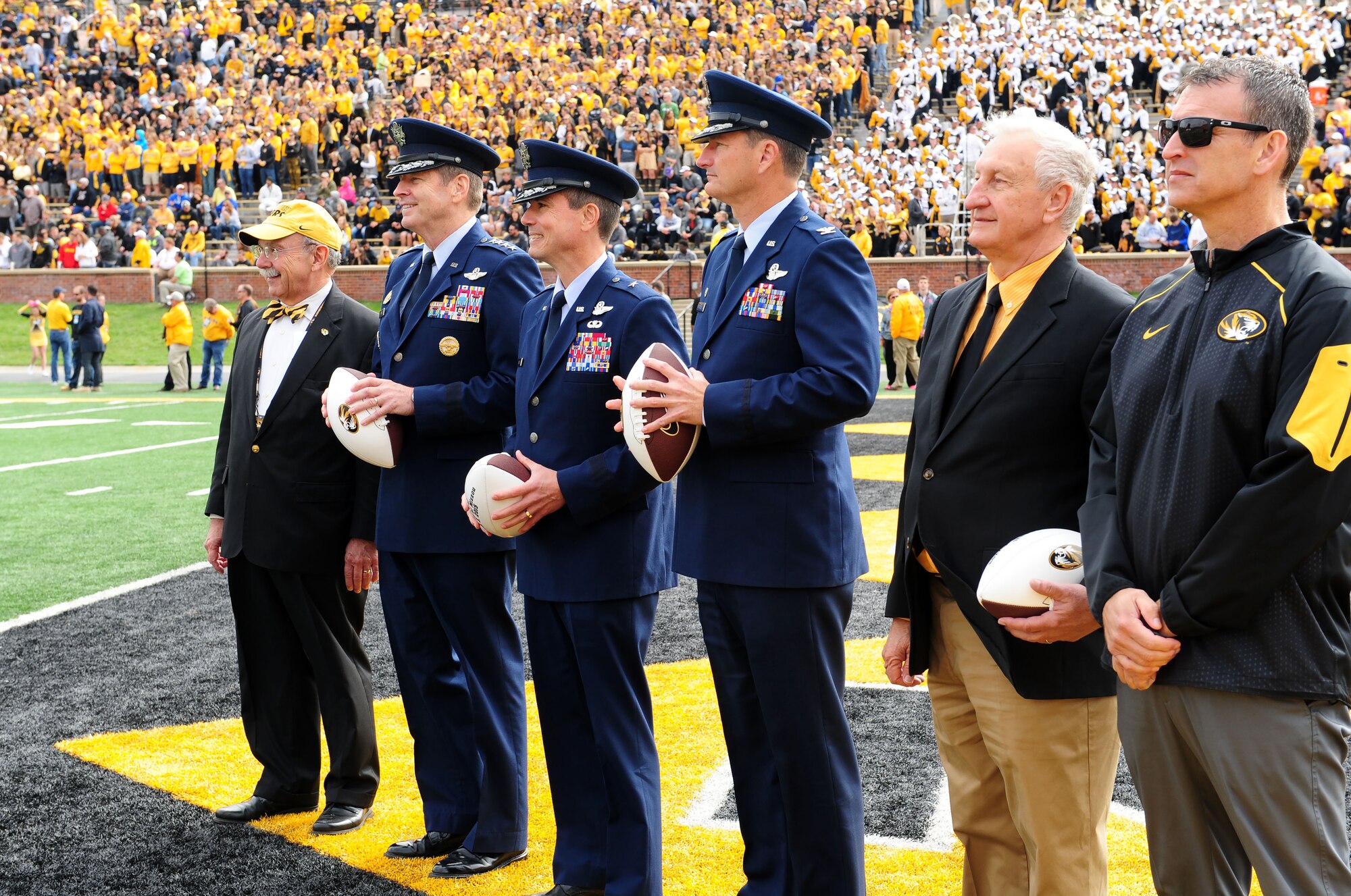 From left, R. Bowen Loftin, University of Missouri chancellor, Gen. Robin Rand, Air Force Global Strike Command commander, Brig. Gen. Paul Tibbets IV, 509th Bomb Wing commander, Col. Michael Francis, 131st Bomb Wing commander, Joe Scallorns, AFGSC civic leader, and Mack Rhoades, University of Missouri director of athletics, stand on the end zone at Faurot Field Oct. 3, 2015, in Columbia, Mo. Each commander and Scallorns received a commemorative football from Rhoades, as part of Mizzou’s military appreciation game. (U.S. Air Force photo by Airman 1st Class Jazmin Smith/Released)