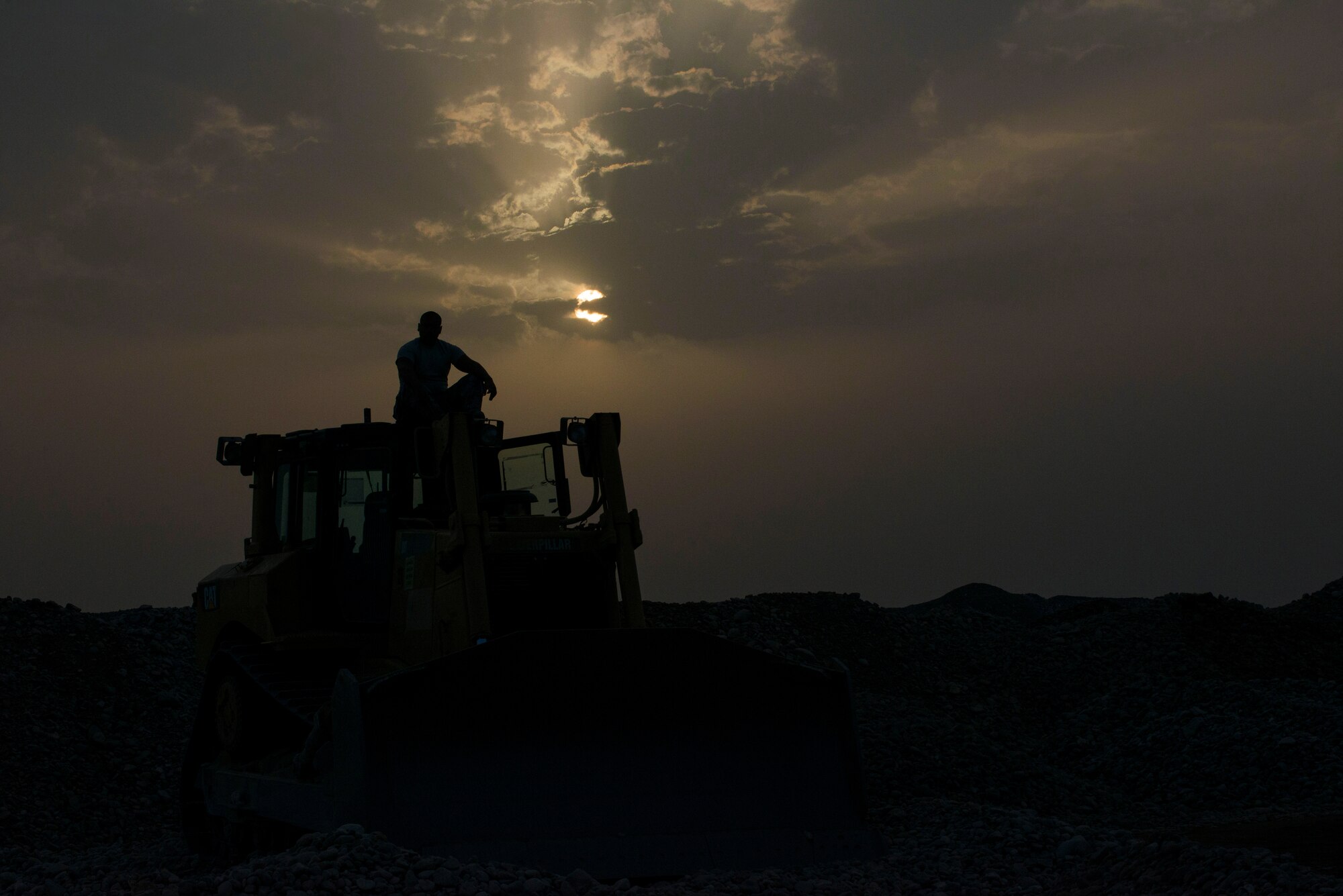 Senior Airman Jordan Tautolo, 435th Construction Training Squadron pavements and construction equipment operator, sits on the top of a bulldozer before the start of a work day Sept. 14, 2015, at Diyarbakir Air Base, Turkey. The ‘Dirt Boys’ of the 435th CTS and 786th Civil Engineer Squadron have worked approximately 12 to 15 hours for the past five weeks to ensure mission readiness of the deployment site. (U.S. Air Force photo by Airman 1st Class Cory W. Bush/Released)