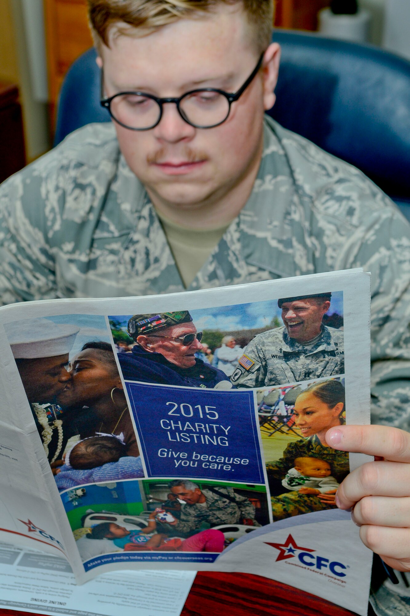 Senior Airman Darrin Proffitt, 51st Fighter Wing executive administration, reads the 2015 charity listing for the annual Combined Federal Campaign-Overseas on Osan Air Base, Republic of Korea, Oct. 8, 2015. The CFC, working hand-in-hand with the United Way, is the world’s largest annual workplace charity campaign. The CFC was established in 1961 to promote philanthropy by providing a focused, cost-effective fundraising effort to federal employees. The campaign kicked off Sept. 21 and is scheduled to run until Nov. 20. (U.S. Air Force photo/Senior Airman Kristin High)