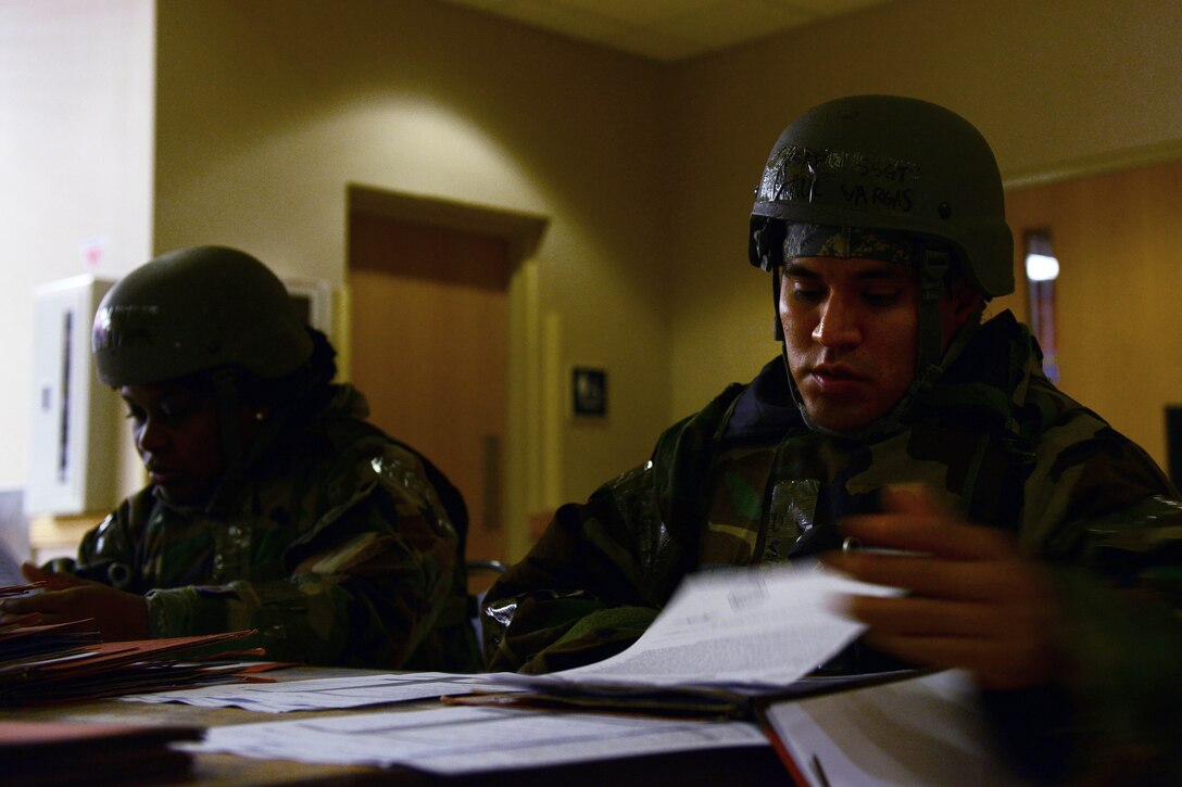 Staff Sgt. Saul Vargas, 8th Force Support Squadron individual personnel readiness NCO in charge, reviews mobility folders of Airmen acting as follow-on forces during Beverly Pack 16-1 at Kunsan Air Base, Republic of Korea, Oct. 6, 2015. The 8th Force Support Squadron plays a vital role when it comes to ensuring follow-on forces have what they need to conduct their mission. (U.S. Air Force photo by Staff Sgt. Nick Wilson/Released)