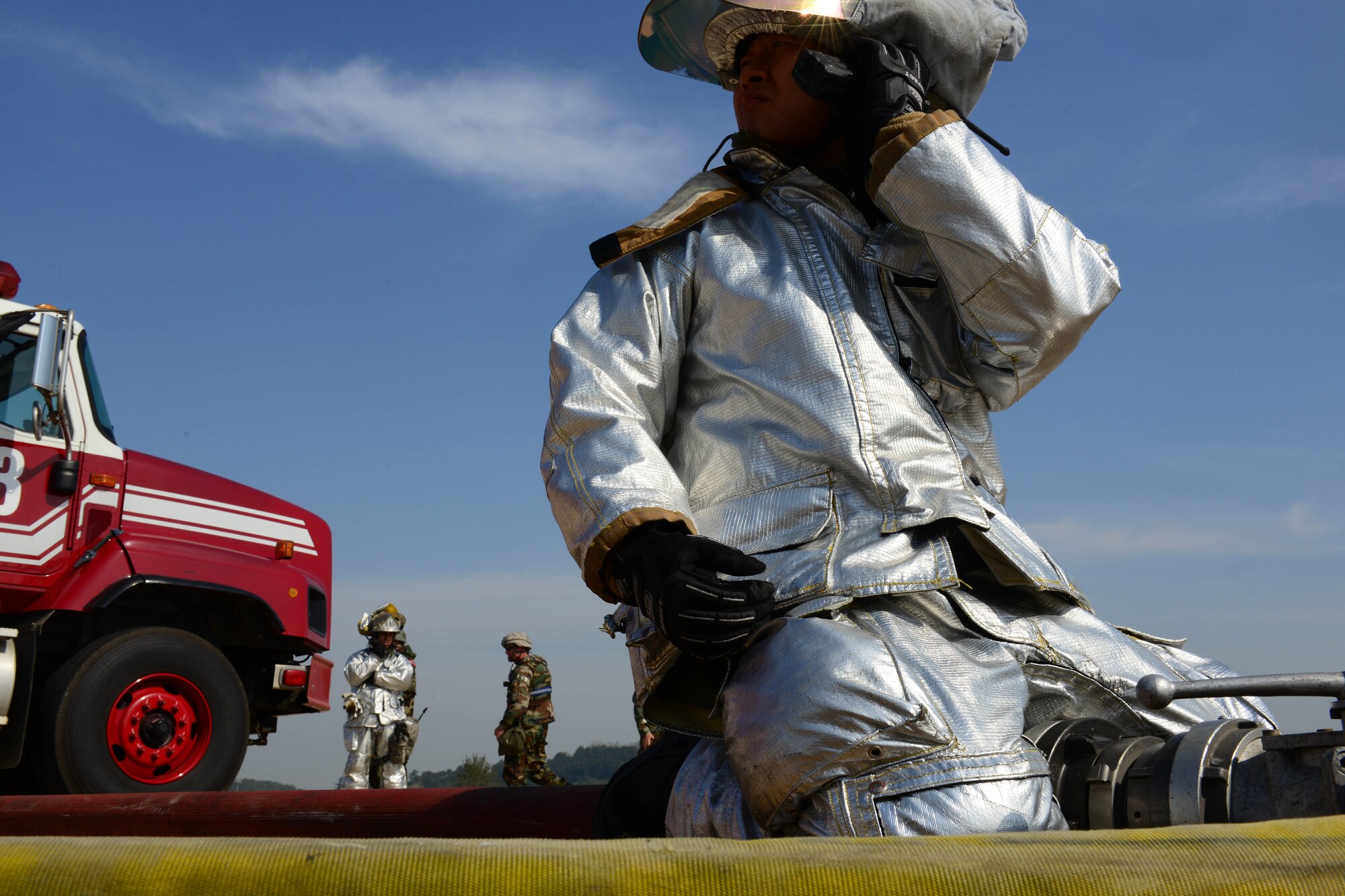 Son U Yi, 8th Civil Engineer Squadron driver operator listens in over the radio while helping control the water being provided to extinguish an aircraft fire exercise during Beverly Pack 16-1 at Kunsan Air Base, Republic of Korea, Oct. 07, 2015. The radio is used to help the communication be passed along throughout the group to try to help the exercise run as smoothly as possible. (U.S. Air Force photo by Senior Airman Ashley L. Gardner/Released)