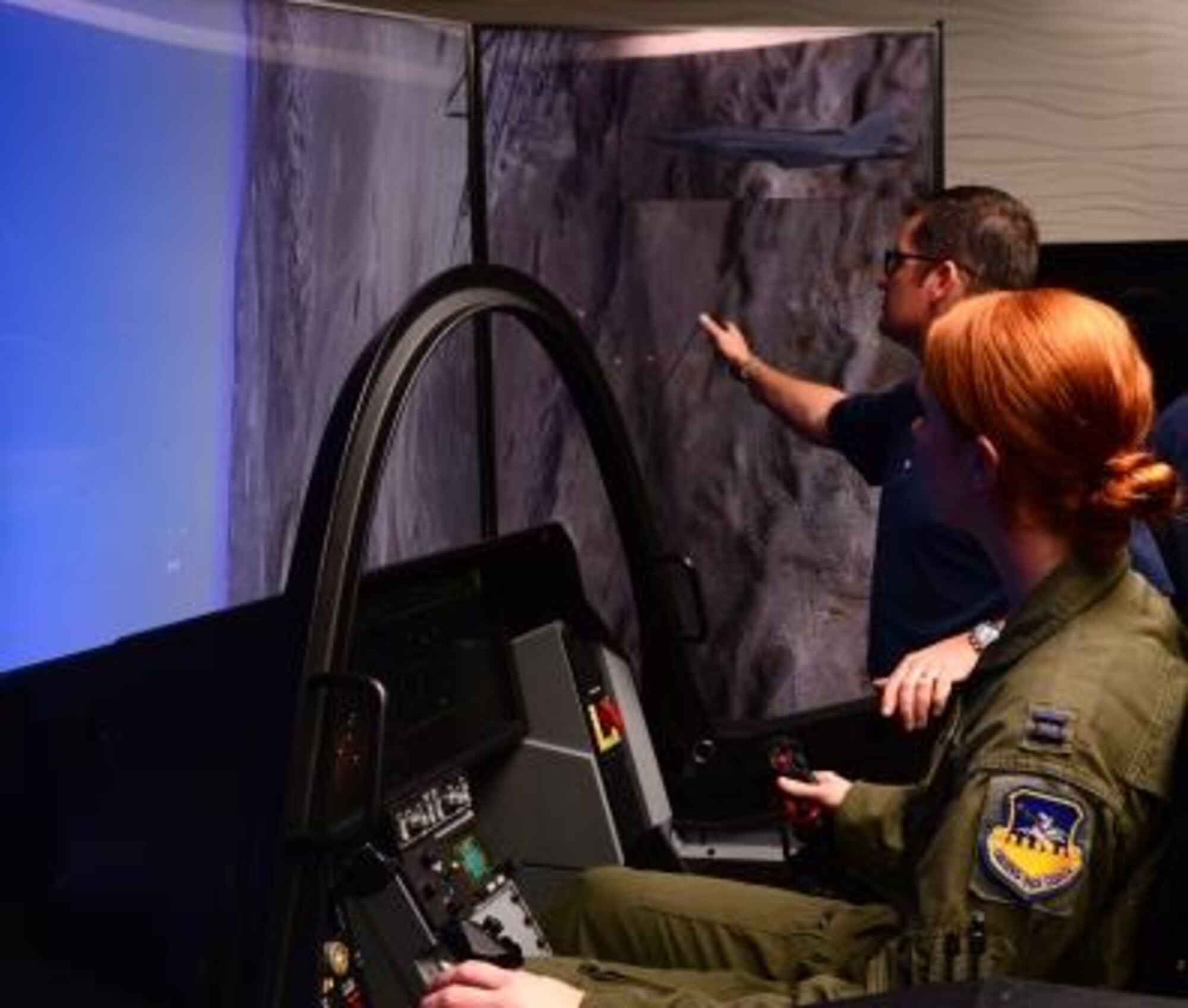 Capt. Brooklynn Knight, 25th Fighter Squadron chief of scheduling, tries out the F-35 Lightning II demonstrator with assistance from Lockheed Martin simulator instructor Matt Cliver Oct. 8, 2015, at Osan Air Base, Republic of Korea. Airmen from across base came out to get a chance to sit in the cockpit of the most advanced fighter aircraft to date. (U.S. Air Force photo by Staff Sgt. Benjamin Sutton) 
