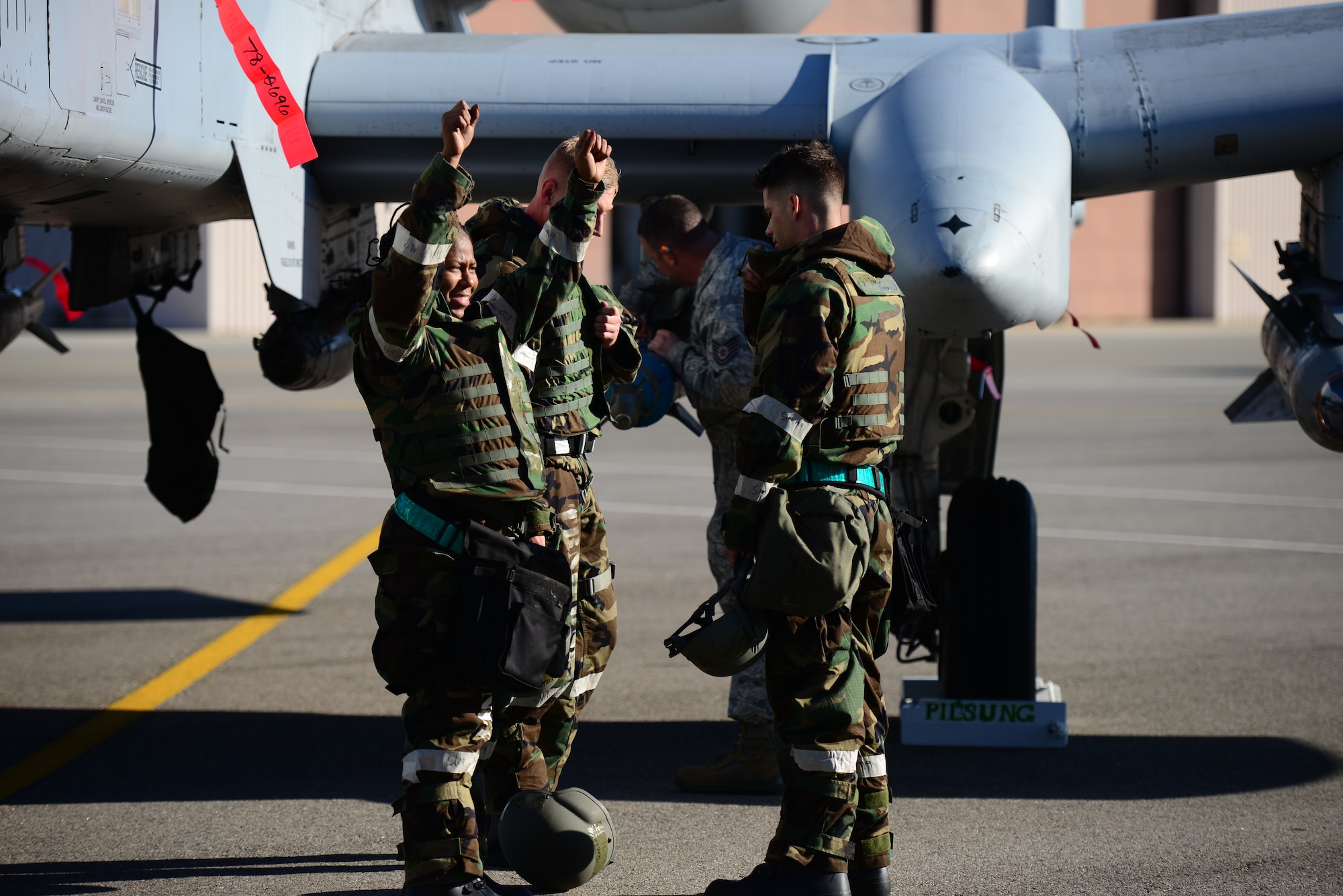 Staff Sgt. Tameka Lindsay, 25th Aircraft Maintenance Unit weapons loader, throws her arms into the air in victory as she finds out her load team is the first to fully complete the practical demonstration of skill portion of the quarterly load competition held at Osan Air Base, Republic of Korea, Oct. 9, 2015. The quarterly event is actually a qualification test for the competing technicians to maintain their mission readiness status. 
(U.S. Air Force photo/Staff Sgt. Amber Grimm)
