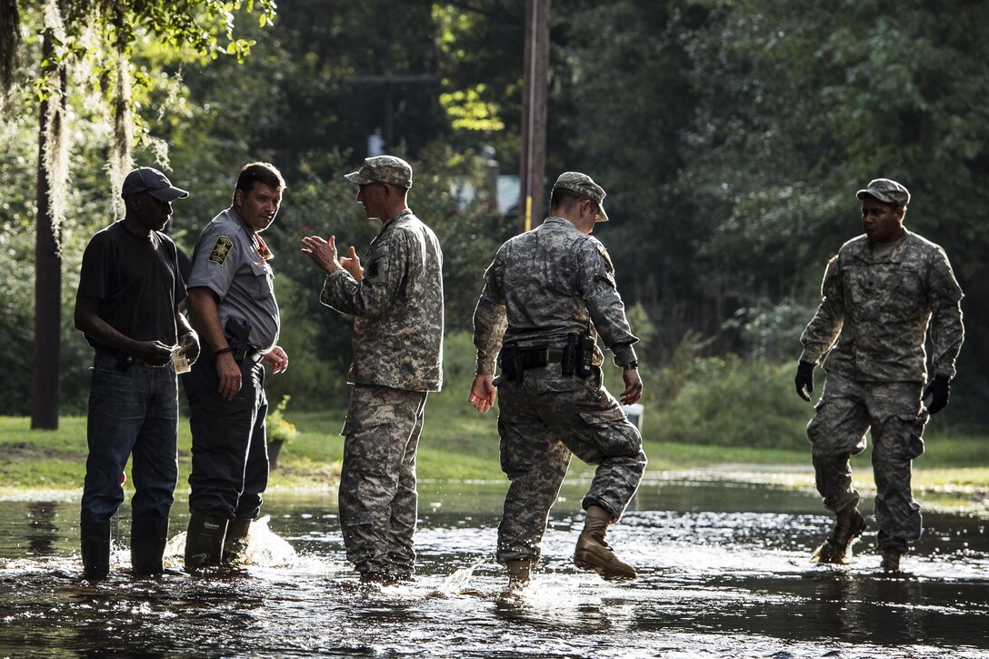 South Carolina National Guard Soldiers from Alpha Company, 1st Battalion, 118th Infantry Regiment, unload sandbags to help  residents protect their property Oct. 9, 2015 in Parkers Ferry, S.C. The historic flooding, which has caused damage, destruction and death throughout South Carolina, has been the result of record-setting rainfall during what is being considered a 1,000-year event caused by Hurricane Joaquin as it traveled up the East Coast. (U.S. Air Force photo by Staff Sgt. Perry Aston/Released)