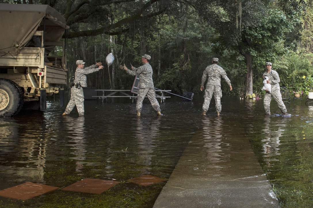 South Carolina Army National Guardsmen unload sandbags to help a resident in Parkers Ferry, S.C., Oct. 9, 2015, in the aftermath of historic flooding in the state. The soldiers are with Company A, 1st Battalion, 118th Infantry Regiment. U.S. Air Force photo by Staff Sgt. Perry Aston