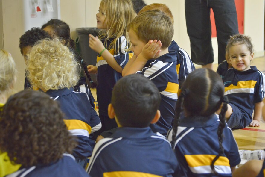 Students of the Compass International School Doha cover their ears and they listen to the sounds of a home fire alarm as part of Fire Prevention Week educational seminars from airmen of the 379th Expeditionary Civil Engineer Squadron Fire Department October 8, 2015 in Doha, Qatar. (U.S. Air Force photo/Staff Sgt. Alexandre Montes)
