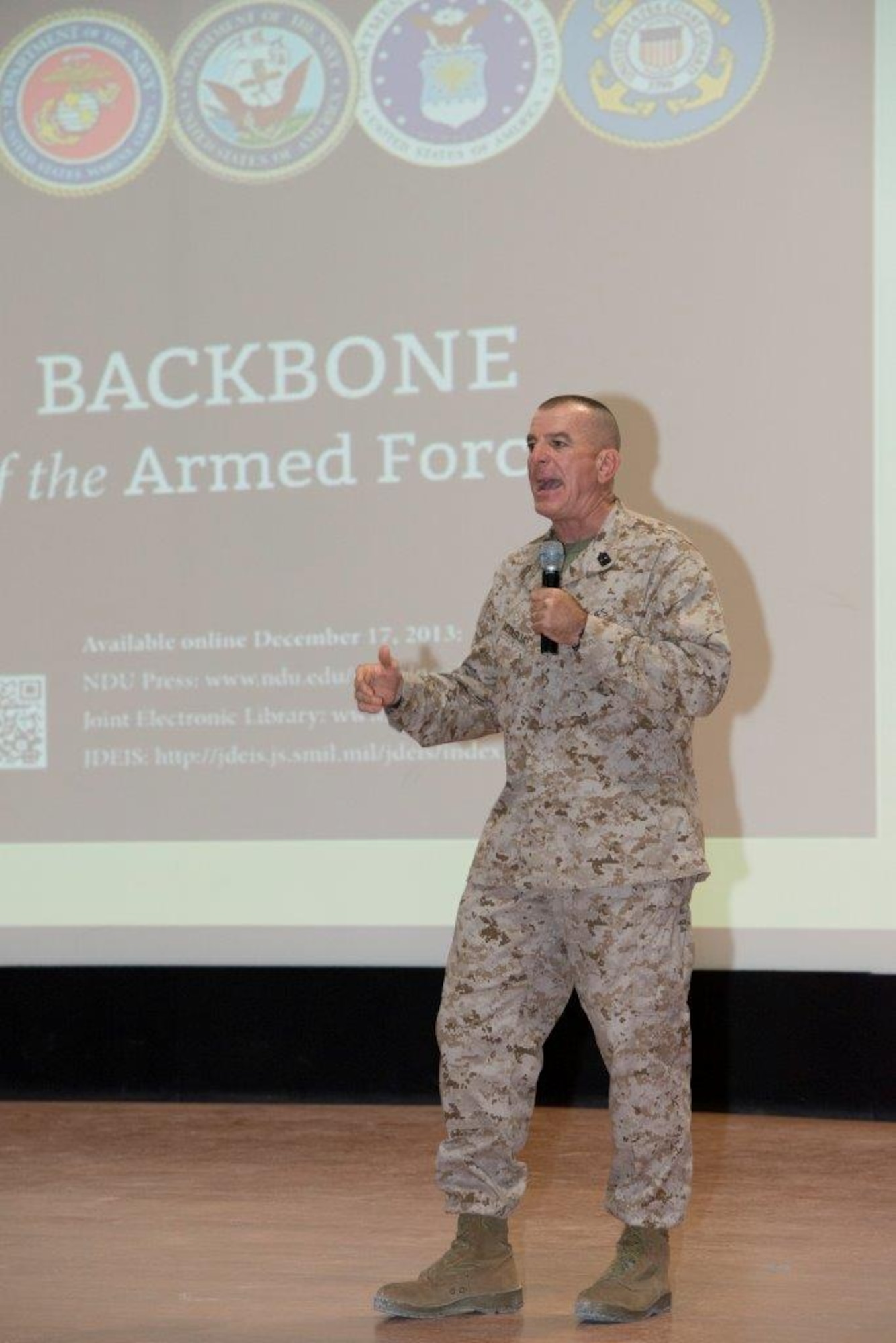 Sgt. Maj. Bryan Battaglia, Senior Enlisted Advisor to the Chairman of the Joint Chiefs of Staff, discusses the book “Noncommissioned Officer and Petty Officer: Backbone of the Armed Forces,” during an Enlisted All-Call with more than 400 members of Al Udeid Air Base, Qatar at the Coalition Compound Theater Oct. 8, 2015. The book, Battaglia said, is one-of-a-kind and provides a comprehensive explanation of what’s expected of enlisted leaders across America’s armed services. During the All-Call, Battaglia also discussed professional development, joint missions and the Department of Defense’s bi-annual award review. He also recognized 10 service members for excellent performance. (U.S. Air Force Photo/Tech. Sgt. James Hodgman) 