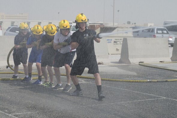 Service members deployed to Al Udeid Air Base, Qatar participated in the Fire Muster, a firefighter skills competition on Oct. 10, 2015. The competition featured numerous challenges for would-be fire fighters, including a skills obstacle course and water jousting. Nearly 100 people took part in the event, which organizers said was designed to provide people with an idea of what firefighters have to deal with on a regular basis. (U.S. Air Force Photo/Tech. Sgt. James Hodgman)